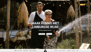 Webdesign Limburg | Celebrating couple spraying champagne outdoors with string lights, overlaid text promoting Limburgse wijn (Limburg wine) — hero banner